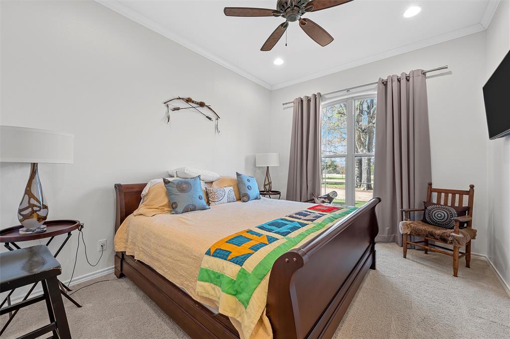 1170 Lumkins Road Forreston, TX 76041 - Photo 14 of 40 a bedroom with a bed a chandelier and a chair