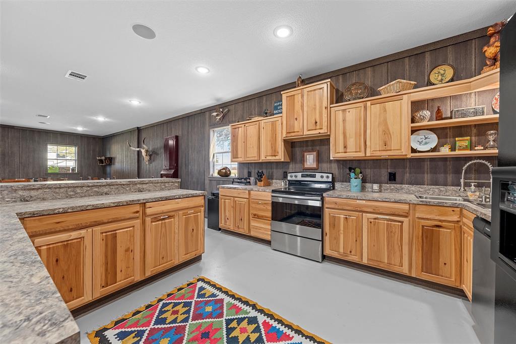 1170 Lumkins Road Forreston, TX 76041 - Photo 27 of 40 a kitchen with stainless steel appliances granite countertop a sink and cabinets