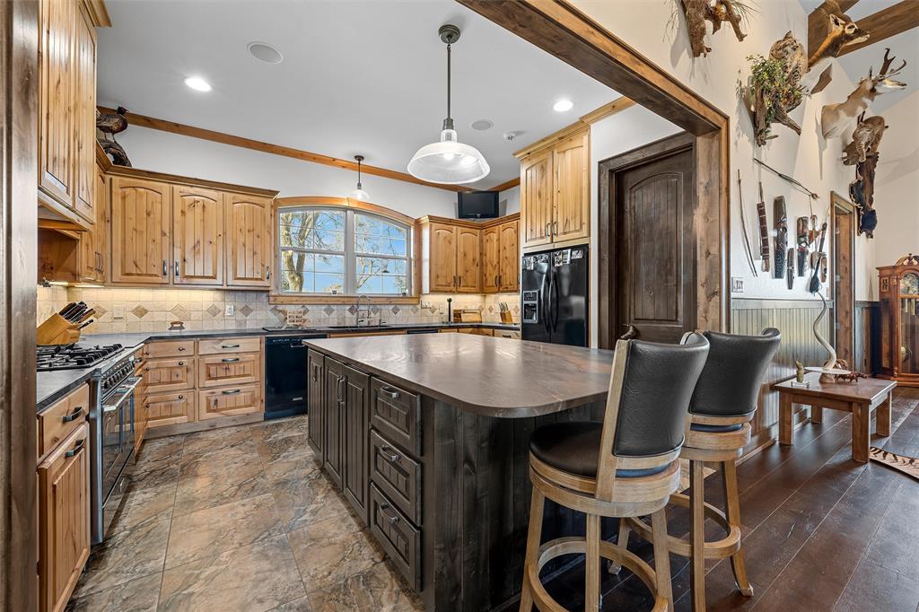1170 Lumkins Road Forreston, TX 76041 - Photo 7 of 40 a kitchen with stainless steel appliances granite countertop a sink a stove and a refrigerator