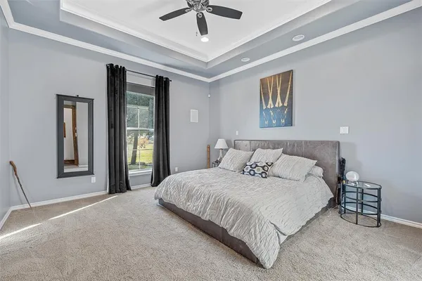 a bedroom with a large bed and a chandelier
