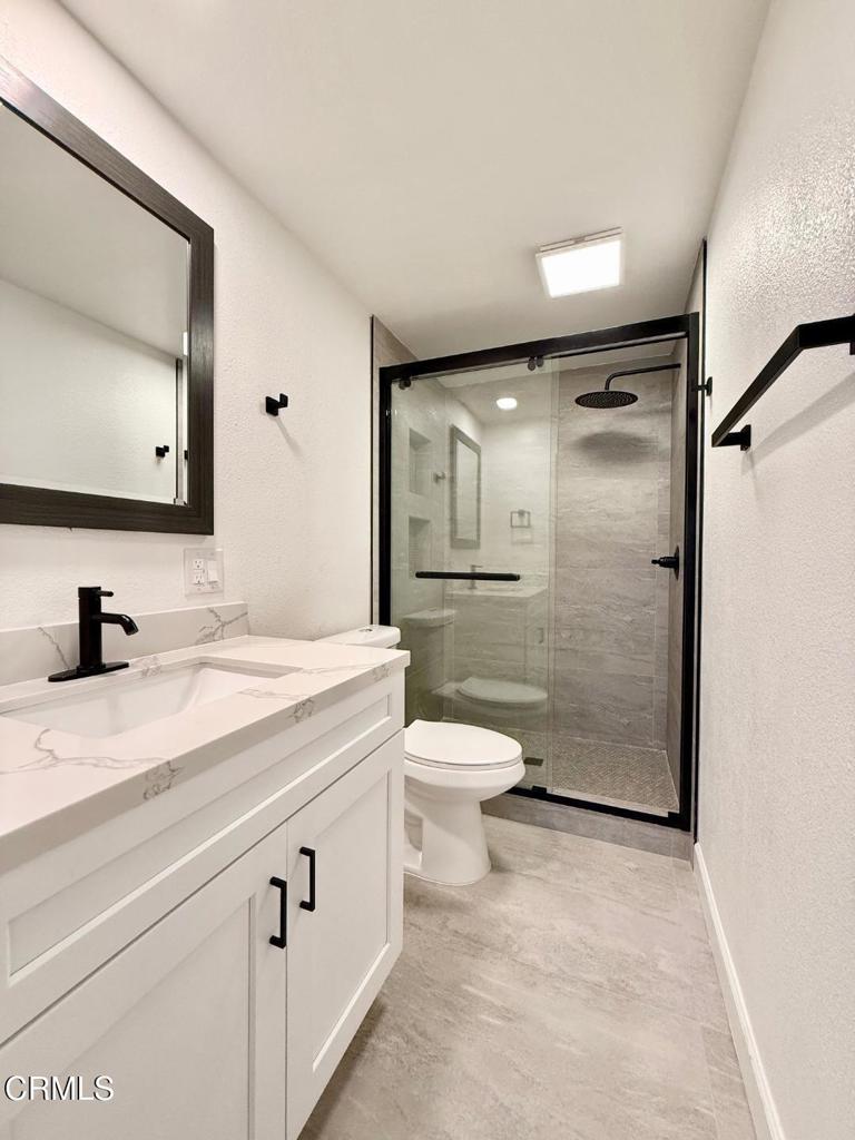 225 South Ventura Road, Unit 79 Port Hueneme, CA 93041 - Photo 19 of 28 a bathroom with a granite countertop sink toilet and shower