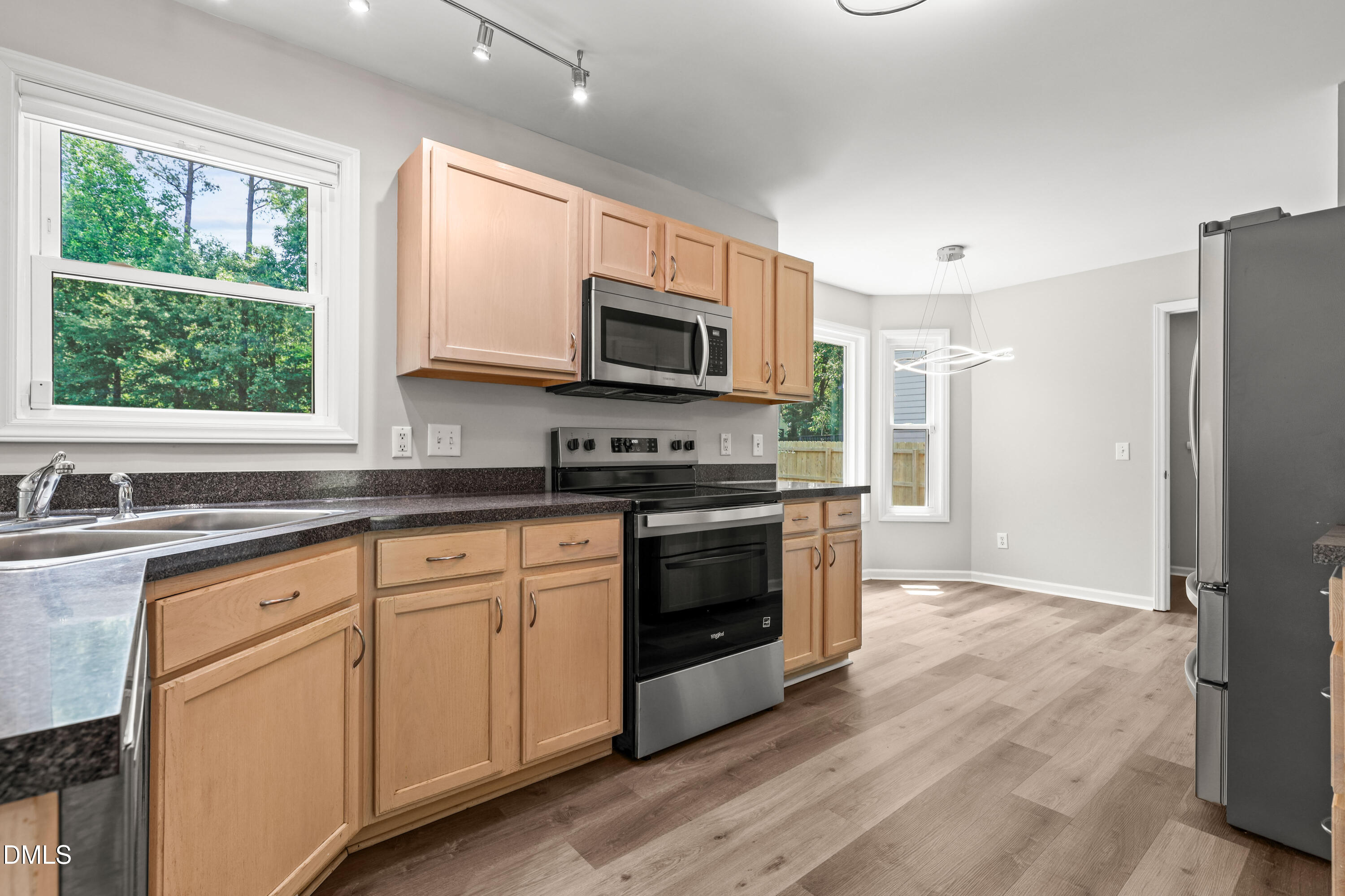 3015 Rennit Court Raleigh, NC 27603 - Photo 10 of 40 a kitchen with granite countertop a refrigerator a sink a stove a microwave a cabinets and wooden floor
