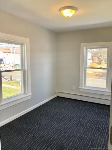 an empty room with wooden floor and window