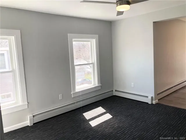 an empty room with wooden floor and entrance