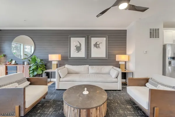 a living room with furniture a lamp and a potted plant