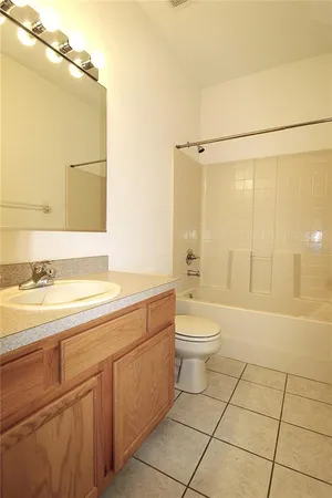 a bathroom with a granite countertop sink a toilet a mirror and shower