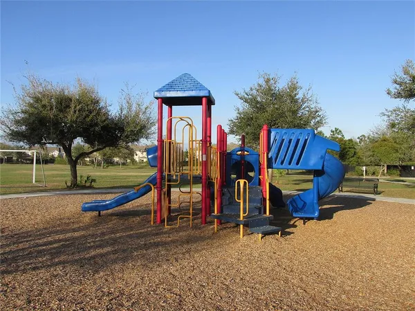 a view of a park with slide and bench