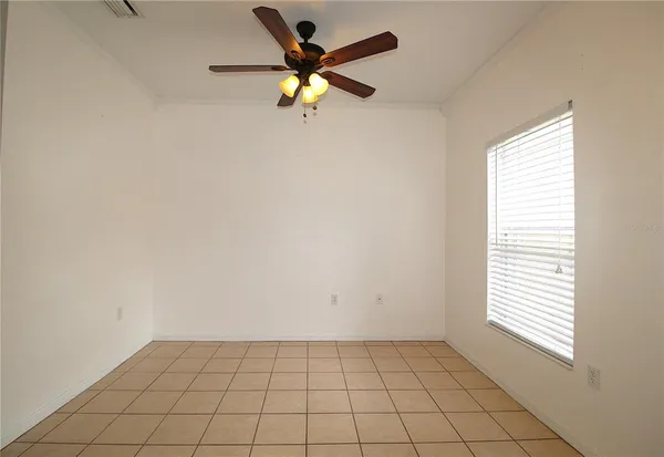 an empty room with a window and a fan