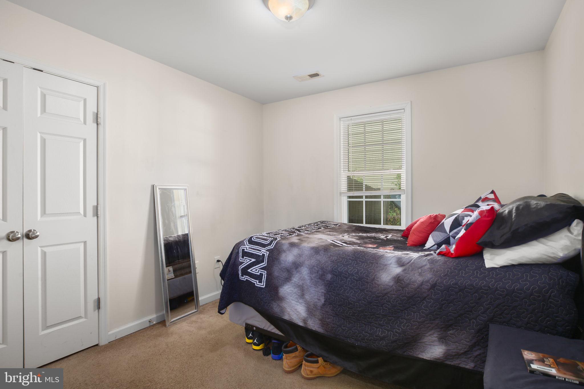 317 12th Street Colonial Beach, VA 22443 - Photo 23 of 28 a bed sitting in a bedroom next to a window