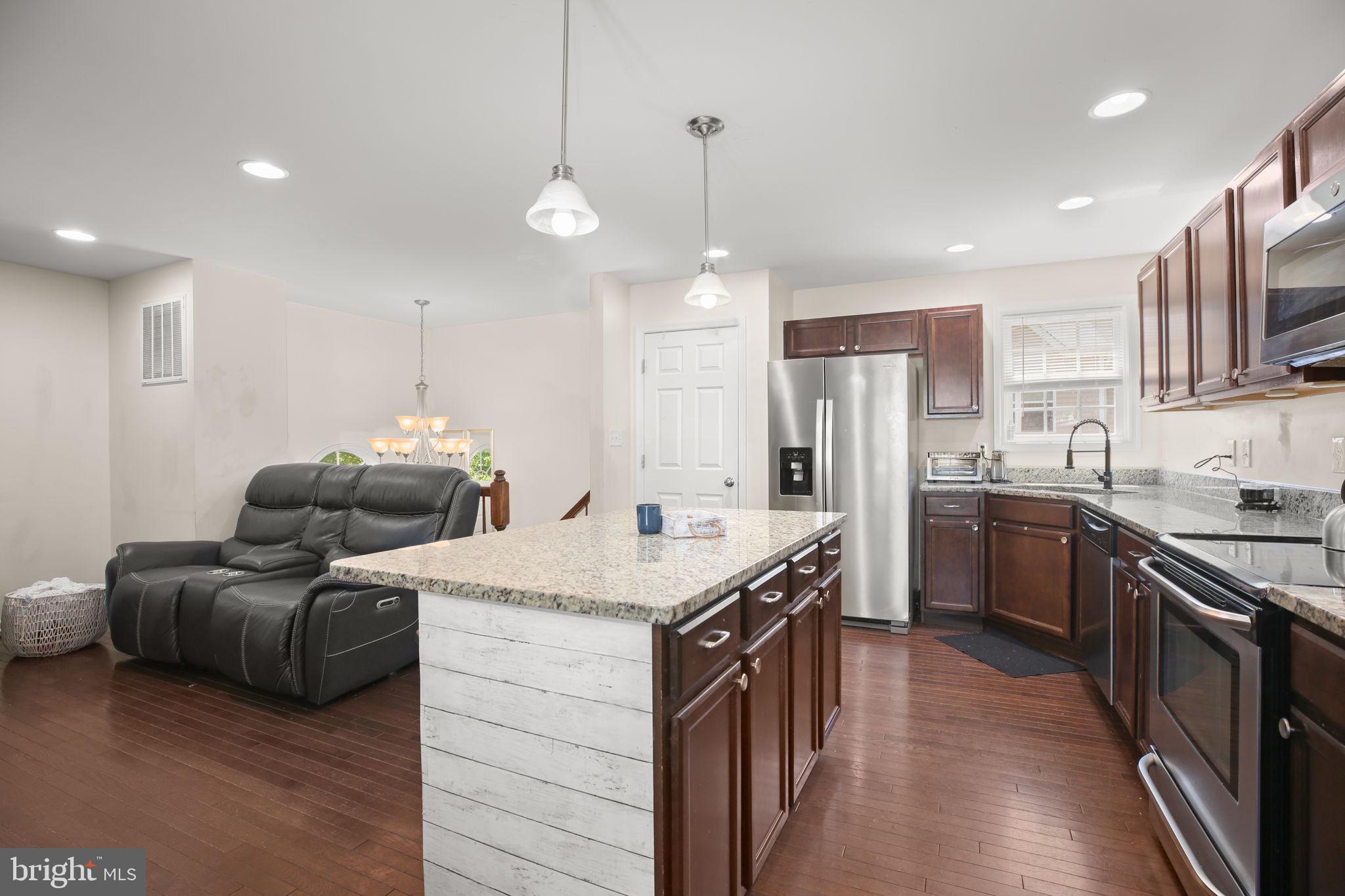 317 12th Street Colonial Beach, VA 22443 - Photo 6 of 28 a kitchen with stainless steel appliances kitchen island granite countertop a sink a stove and a refrigerator