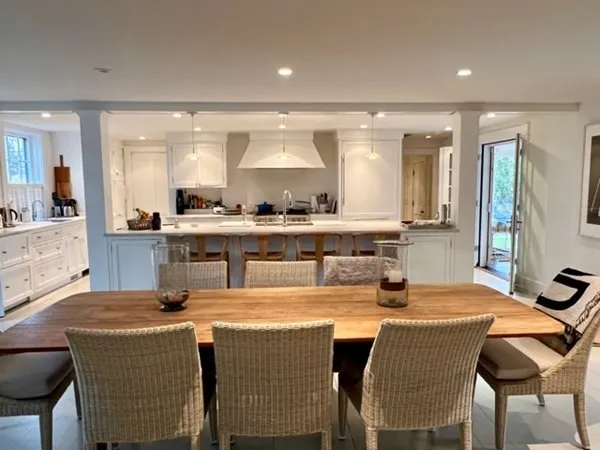 a kitchen with stainless steel appliances granite countertop a table chairs sink and cabinets