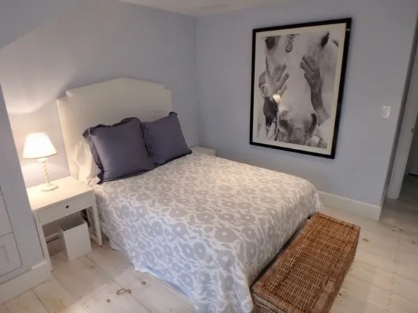 a large bed sitting in a bedroom next to a window