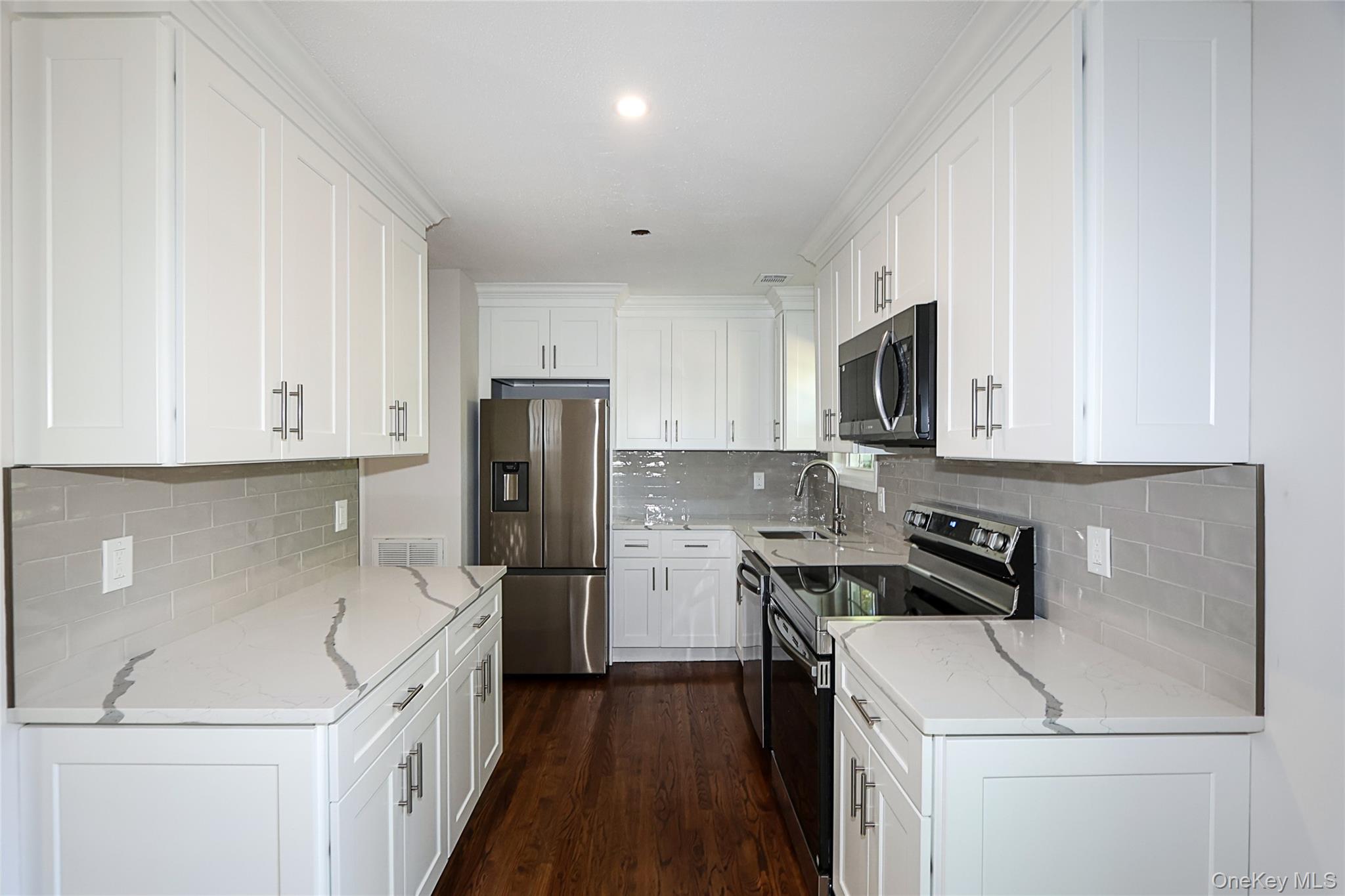 10 Smith Yaphank, NY 11980 - Photo 11 of 26 a kitchen with a sink a stove and refrigerator