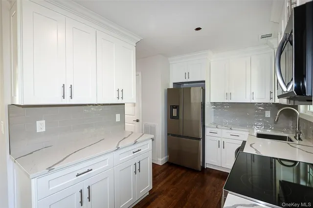 a kitchen with a refrigerator sink and cabinets