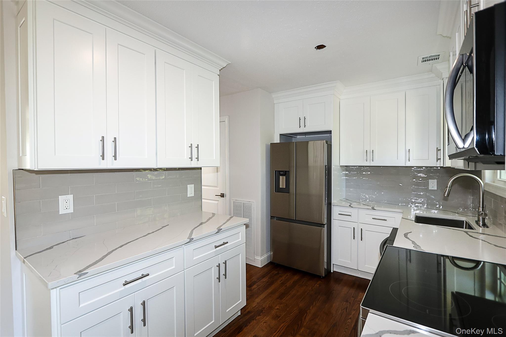 10 Smith Yaphank, NY 11980 - Photo 12 of 26 a kitchen with a refrigerator sink and cabinets