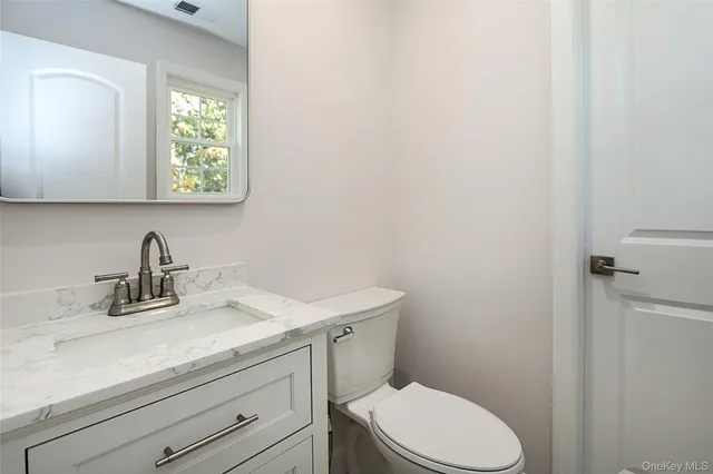 a bathroom with a sink a toilet and a window