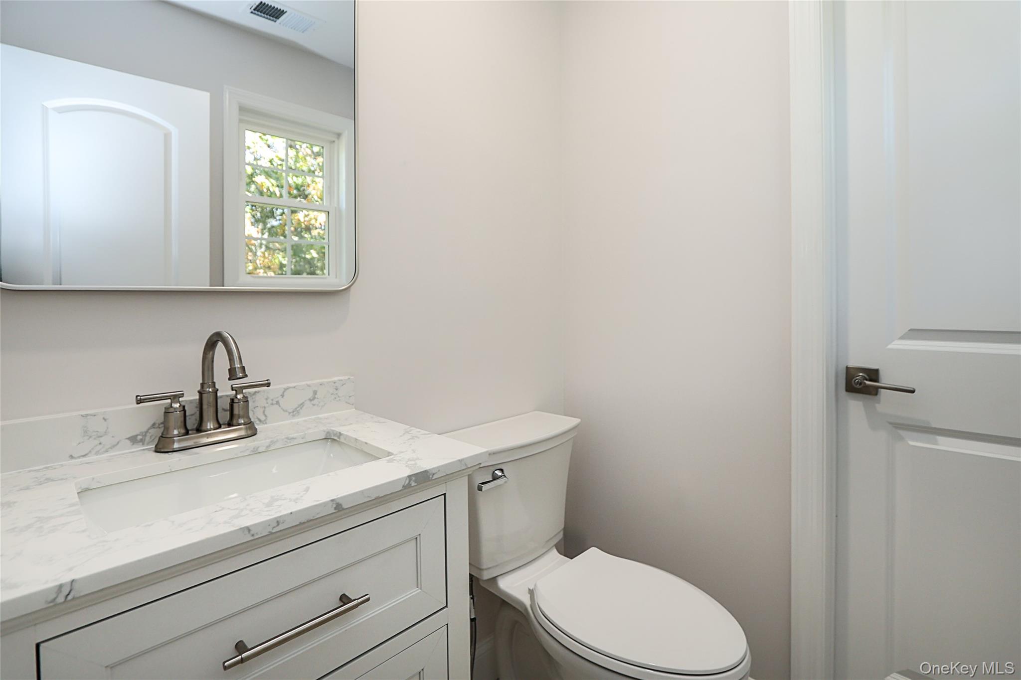 10 Smith Yaphank, NY 11980 - Photo 17 of 26 a bathroom with a sink a toilet and a window