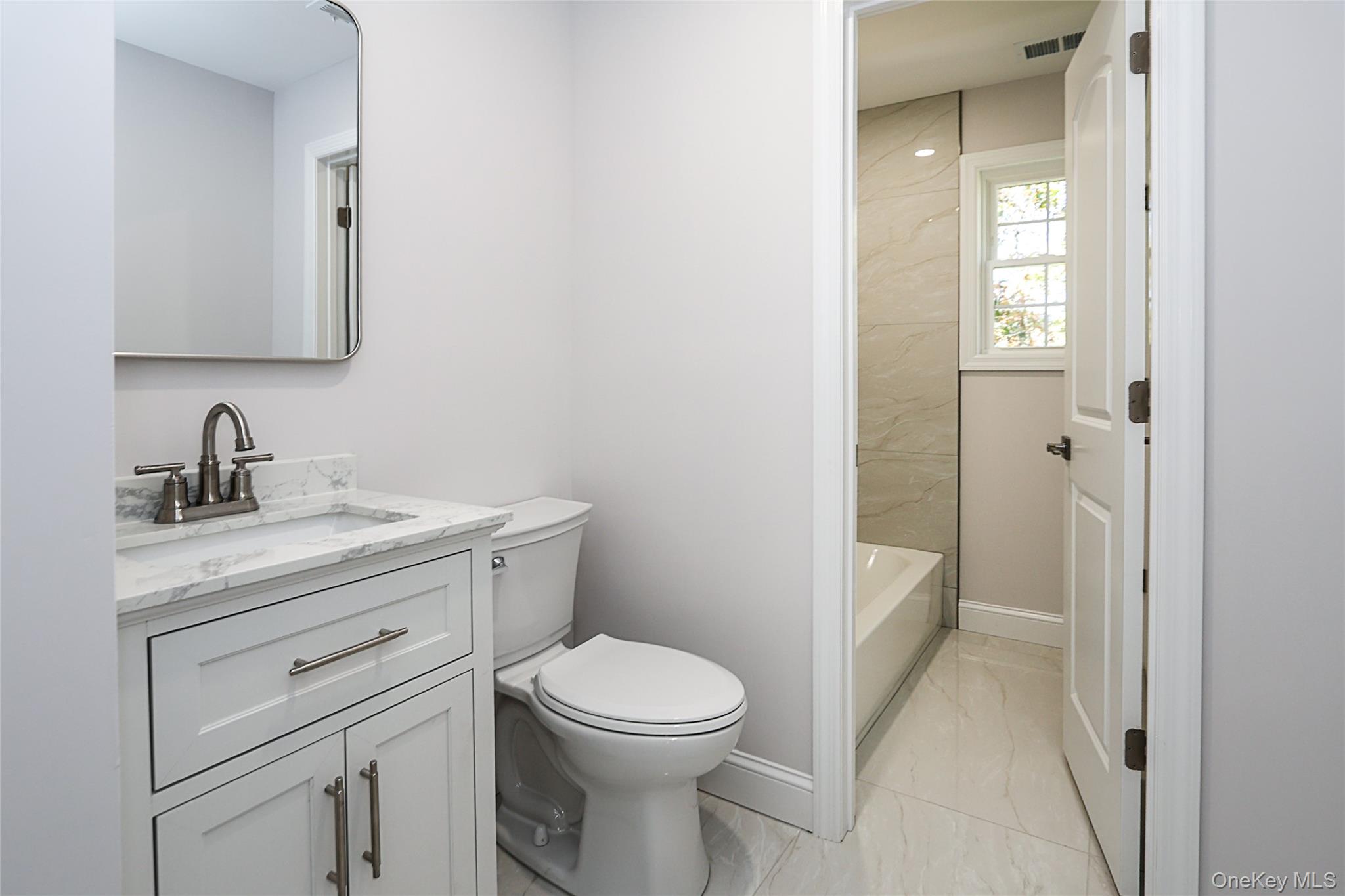 10 Smith Yaphank, NY 11980 - Photo 20 of 26 a bathroom with a toilet a sink a vanity and mirror