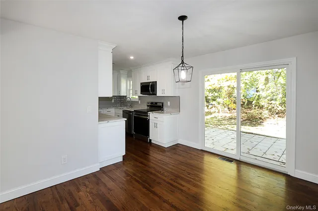 a kitchen with stainless steel appliances granite countertop a stove a sink and a wooden floor