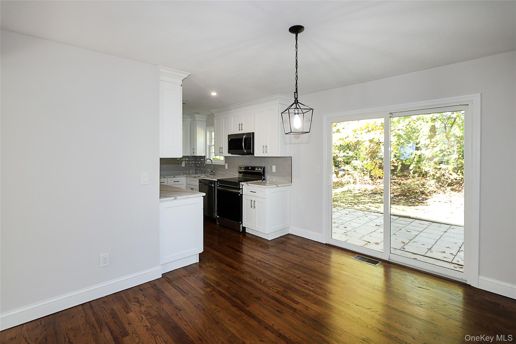 10 Smith Yaphank, NY 11980 - Photo 8 of 26 a kitchen with stainless steel appliances granite countertop a stove a sink and a wooden floor