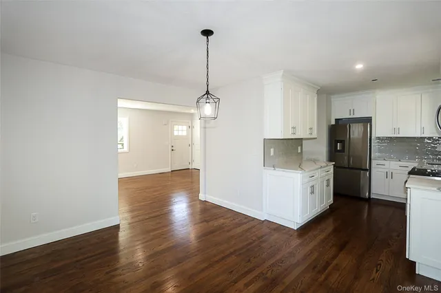 a kitchen with stainless steel appliances a refrigerator and wooden floor