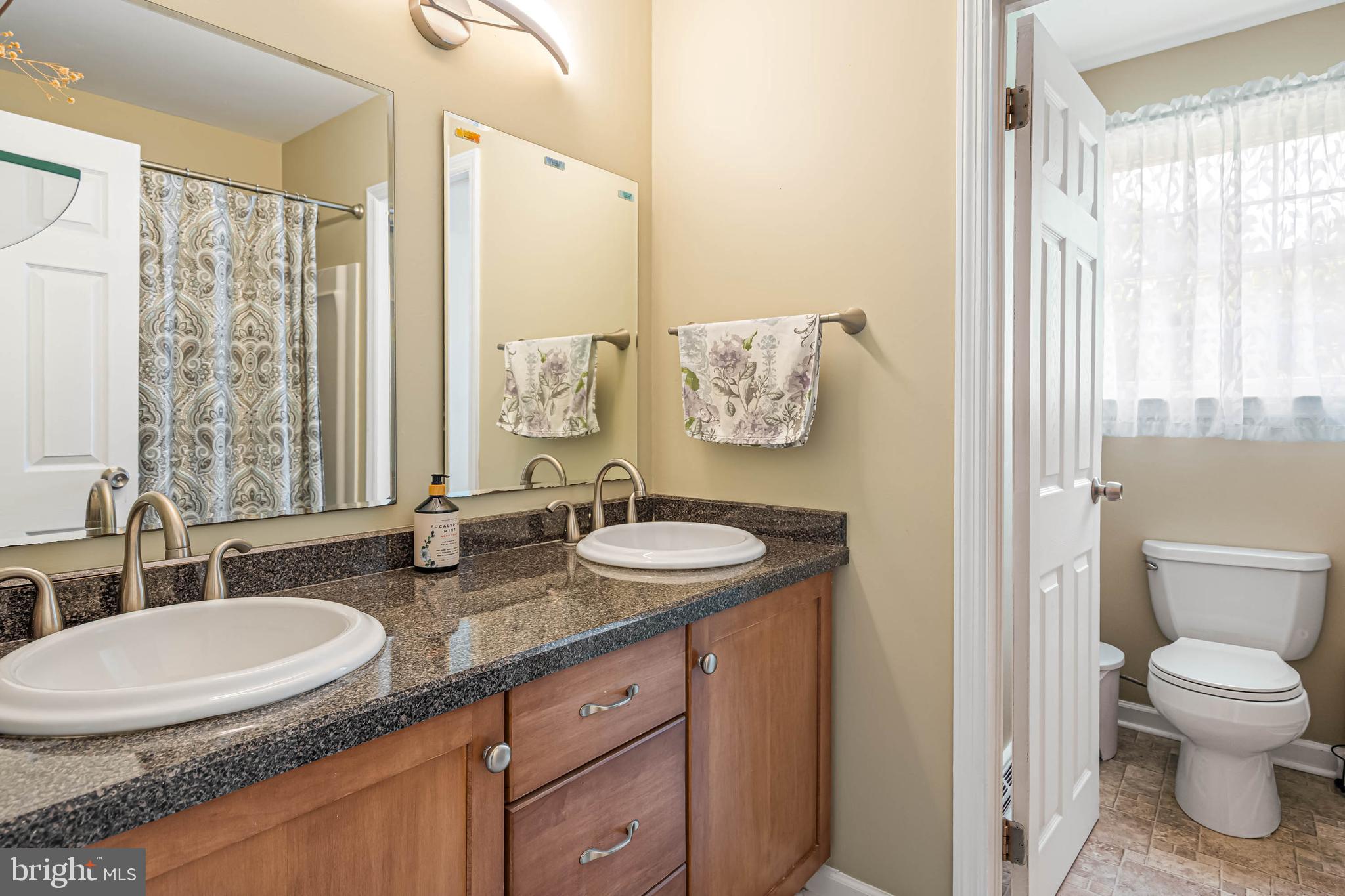 121 Decker Drive Newark, DE 19711 - Photo 28 of 57 a bathroom with double vanity sink a mirror and a toilet