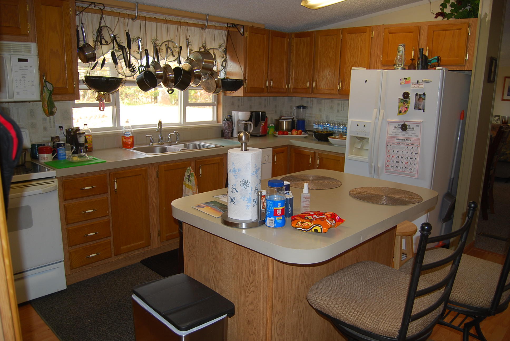 1019 Doe Mountain Road Goodview, VA 24095 - Photo 43 of 53 a kitchen with stainless steel appliances granite countertop a refrigerator a sink dishwasher and a dining table with wooden cabinet