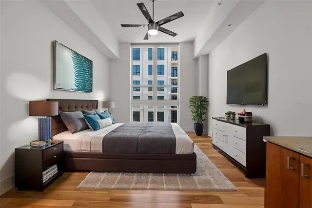 a spacious bedroom with a bed and a flat screen tv