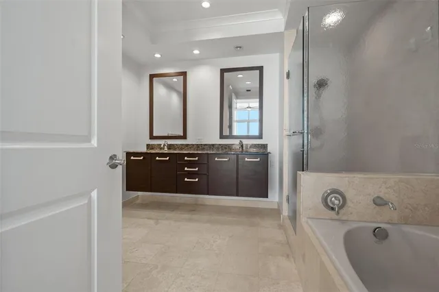 a spacious bathroom with a tub sink and mirror