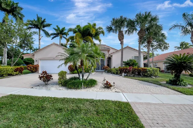 a view of a house with a yard and potted plants