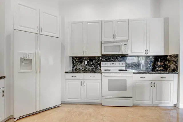 a kitchen with white cabinets and white appliances