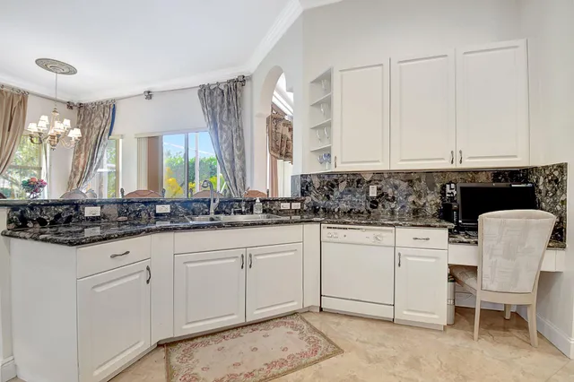 a kitchen with white cabinets and sink