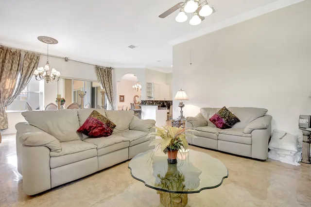 a living room with furniture a chandelier and a dining table