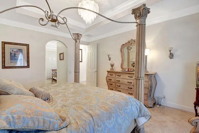 a bedroom with a bed a dresser and cabinets