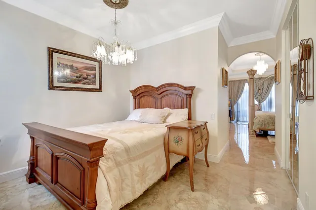 a bedroom with a bed and a chandelier