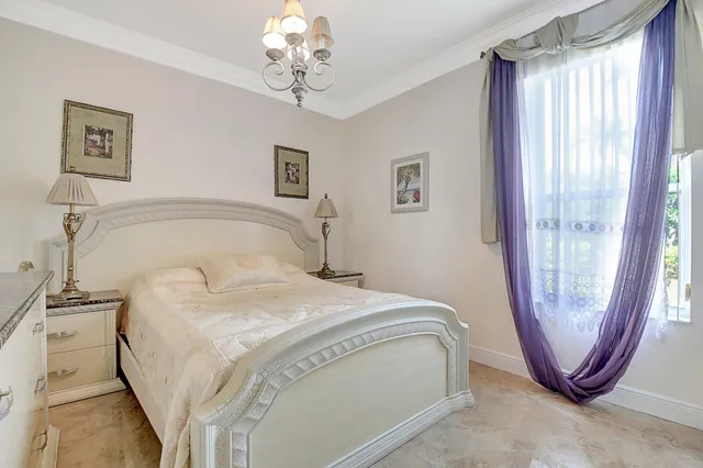 a spacious bedroom with a large bed and a chandelier