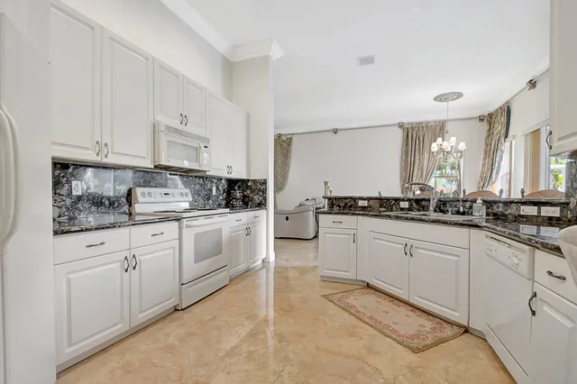 a kitchen with granite countertop white cabinets white stainless steel appliances with a sink and dishwasher
