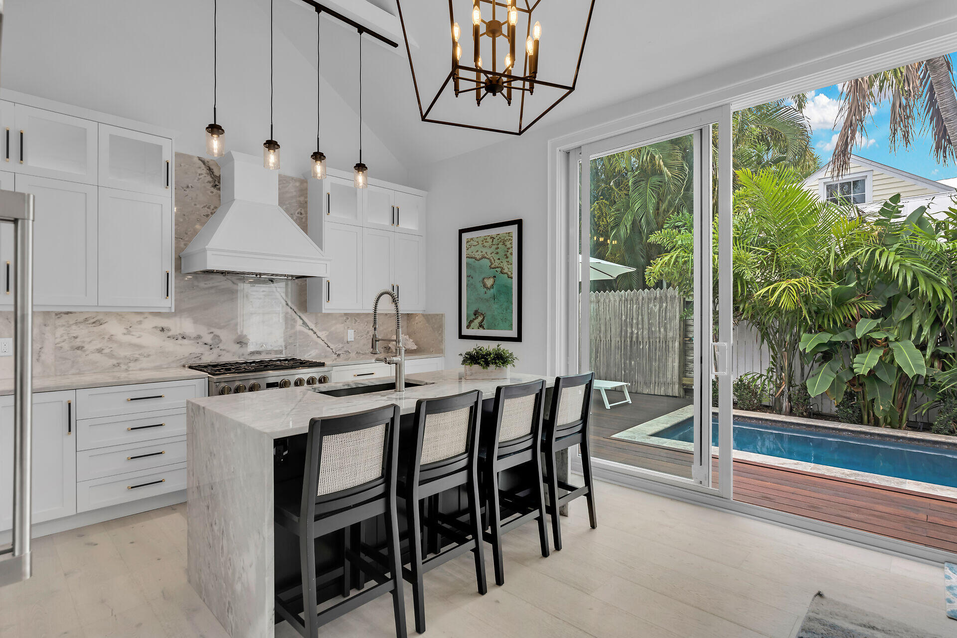 1015 Eaton Street Key West, FL 33040 - Photo 4 of 36 a kitchen with stainless steel appliances granite countertop a stove a refrigerator a dining table and chairs with wooden floor