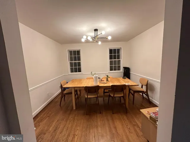 a dining room with a wooden table and chairs