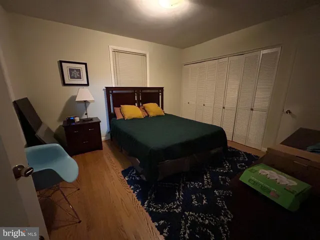 a bedroom with a bed window and dresser