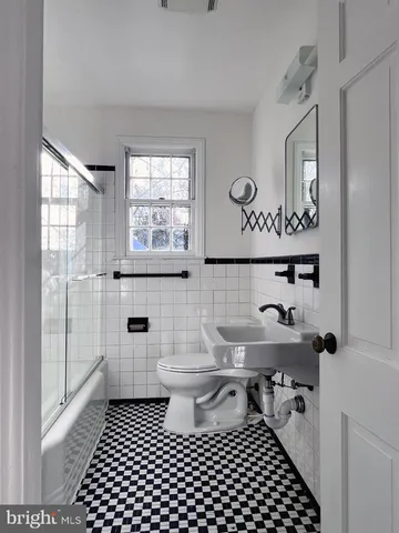 a bathroom with a toilet a sink and a window