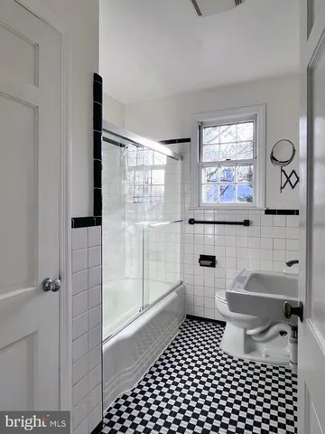 a bathroom with a toilet a window and shower