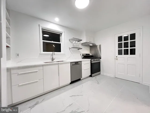 a kitchen with granite countertop white cabinets and white appliances
