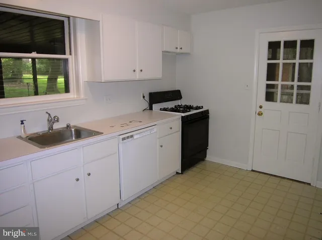 a kitchen with a sink cabinets and window