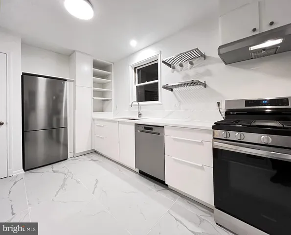a kitchen with stainless steel appliances a refrigerator and a stove top oven