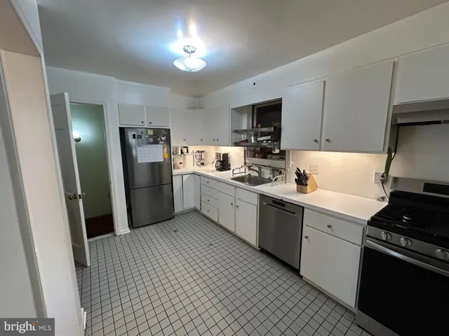 a kitchen with a sink a refrigerator and cabinets