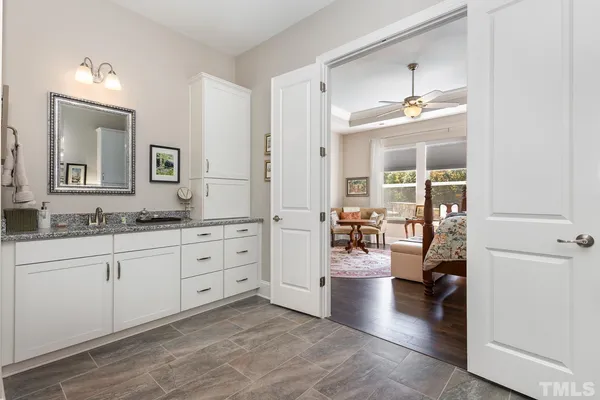 a spacious bathroom with a granite countertop sink and a mirror