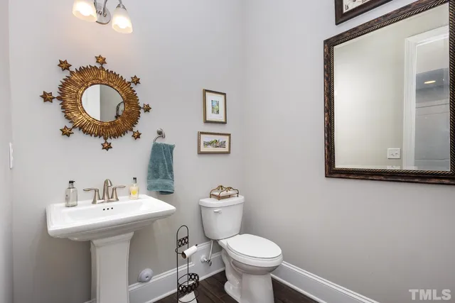 a bathroom with a toilet a sink and mirror