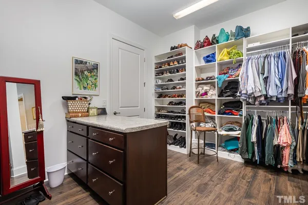 a view of walk in closet with clothes and shoes