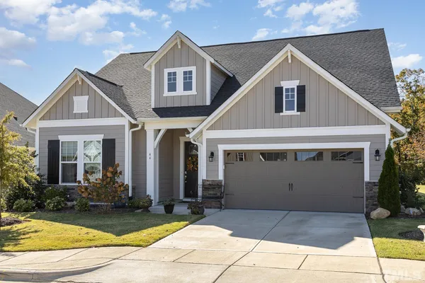 a view of a white house with large windows and plants